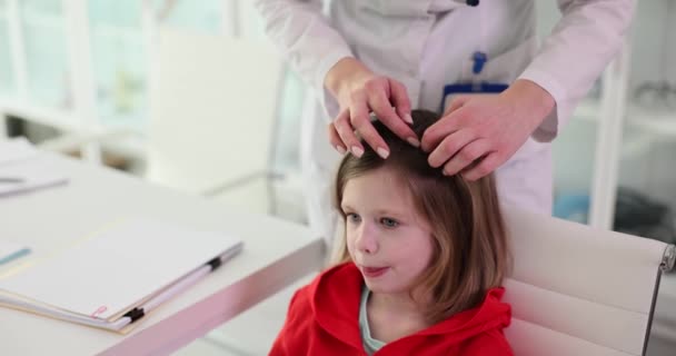 ブレードで医師によって長い髪の女の子の子供の髪をチェックします 医者は頭のライスのための子の髪をチェックし ライスとの侵入の可能性 — ストック動画