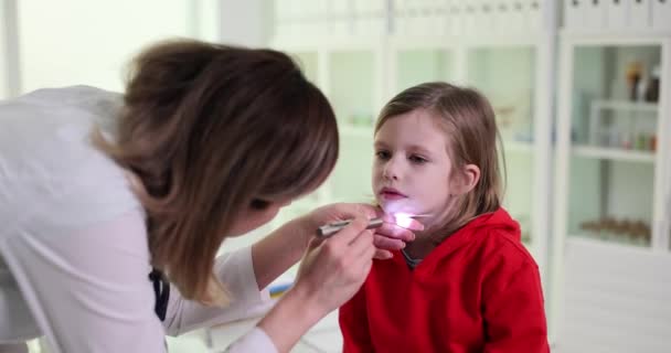 女儿科医生看着小女孩的喉咙 医生怀疑感染流感或病毒 — 图库视频影像