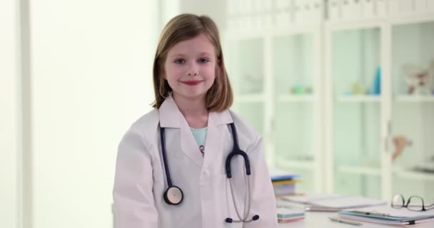 医者の形で美しい少女は手に赤い心臓を保持しています 小児心外科と小児心血管疾患の治療部 — ストック動画