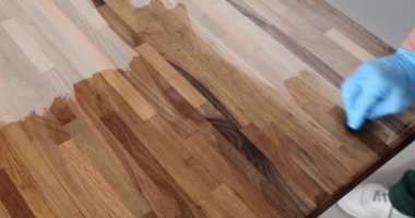 Marangoz ahşap masayı özel yağla kaplıyor. Ahşap ürünlerin korunması