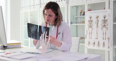 Bilek iskeletlerinin röntgenini tutan ve hastada kemik ağrısını teşhis eden bir doktor. Hastanede kemiklerin ve eklemlerin durumunun profesyonel incelemesi
