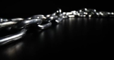 Siyah arka planda gümüş metal zincir. Kısa bağlantıları olan düz metal zincir.