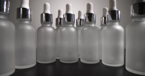 Rij Lege Glazen Cosmetische Flessen Grijze Achtergrond Productie Van Cosmetische — Stockvideo