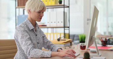 Şirket ofisindeki işyerinde oturan gülümseyen ofis çalışanı tipleri. İyimser çalışan müşterilerle çevrimiçi sohbet yavaş çekim yoluyla iletişim kurar