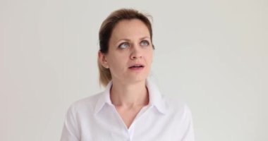 Açık tişörtlü bir kadın odanın tavanına doğru bakıyor. Beyaz arka planda ağır çekimde duran kadın nesneyi takip ediyor
