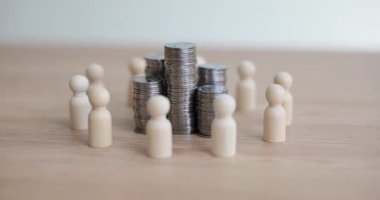 Tahta masadaki beyaz figürlerle çevrili gümüş paralar. Para kazanmak ve iş yerinde çalışan bir grup insan. İşletme geliri