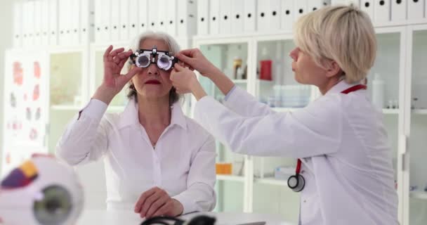 Arzt Stellt Brille Für Ältere Frau Ein Die Schreibtisch Der — Stockvideo