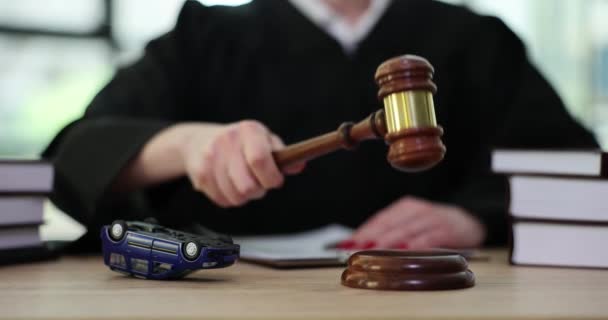 身穿斗篷的女法官敲敲着木槌 坐在桌旁 旁边坐着一辆翻倒的玩具车 法院慢动作中的事故与诉讼概念 — 图库视频影像