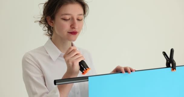 Açık Tişörtlü Gülümseyen Kadın Blogcu Tripoda Şarjörlü Mavi Kağıt Arka — Stok video