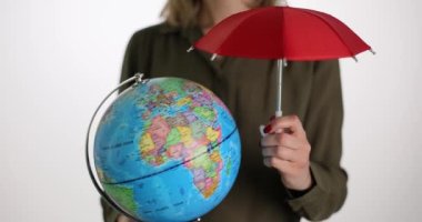 Kadın dünyayı ve kırmızı şemsiyeyi tutuyor. Küresel ısınma nedeniyle gezegeni iklim değişikliğinden kurtaran kadın. Çevre koruma kavramı