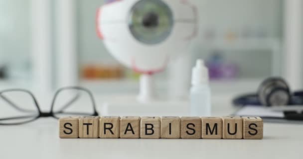 Word Strabismus Gjord Trä Kuber Mot Oftalmologi Utrustning Realistisk Ögonglobsmodell — Stockvideo