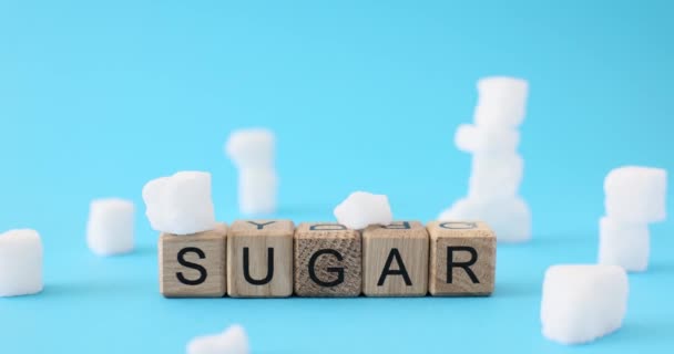 Palabra Azúcar Hecha Cubos Madera Superficie Azul Claro Trozos Azúcar — Vídeo de stock