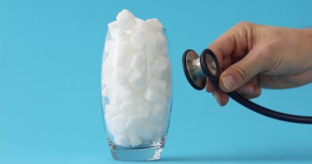 Mann Legt Stethoskop Glas Voller Weißer Zuckerwürfel Arzt Untersucht Auswirkungen — Stockvideo