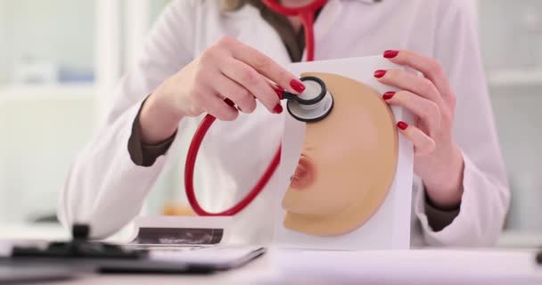 의사들은 청진기를 모형에 유니폼을 여자가 테이블에 검진을 장비를 사용하여 동작을 — 비디오