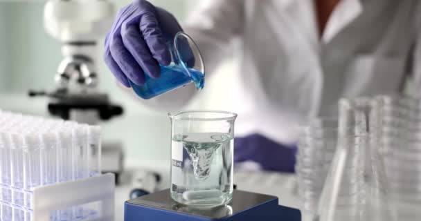 Científico Vierte Reactivo Azul Denso Vidrio Con Agua Limpia Remolino — Vídeos de Stock