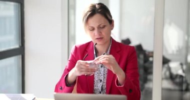 Takım elbiseli kadın çalışan, özel bir bez parçasıyla bardakları siliyor. Kadın aksesuarı pislikten temizlemeye çalışıyor ve ağır çekimde iz bırakıyor.