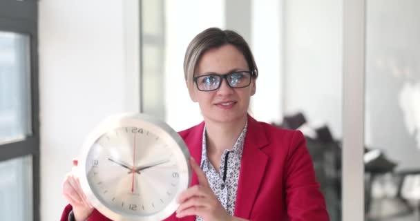 Kobieta Różowym Garniturze Pokazuje Zegar Okrągłym Kształcie Jako Symbole Przesunięcia — Wideo stockowe