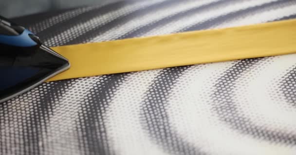 Νοικοκυρά Σιδερώνει Κίτρινη Γραβάτα Χρησιμοποιώντας Συσκευή Ζεστού Ατμού Και Σιδερώστρα — Αρχείο Βίντεο