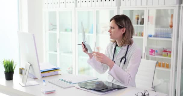 Üniformalı Doktor Klinikteki Masada Oturan Kemik Kırığının Röntgenini Inceliyor Kadın — Stok video