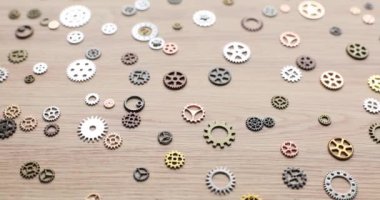 Dişliler ahşap yüzeyde kaotik bir şekilde dağılmış. Düşünce ve işlev çeşitliliği gibi. Mekanizma işlemleri için çeşitli ayrıntıların kavramı