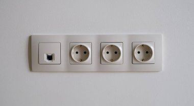 Duvarda kablosuz ağ girişi olan beyaz prizler. Kablo döşeme konsepti