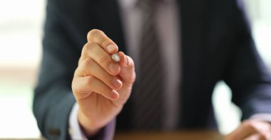 Takım elbiseli bir işadamı sözleşmeyi imzalamak için tükenmez kalemi elinde tutuyor. Belge konsepti sertifikası