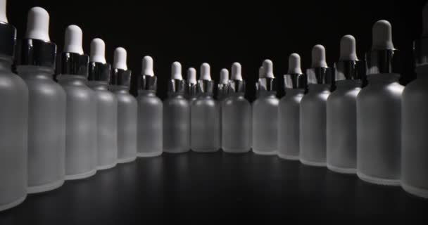 Glasflaschen Mit Organischem Gesichtsserum Stehen Geschwungener Reihe Auf Einem Dunklen — Stockvideo