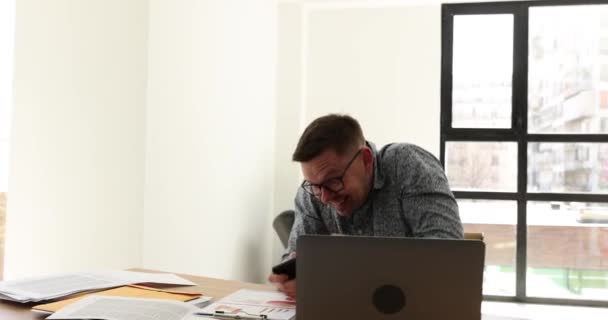 興奮した男はオフィスの職場でビデオゲームで負ける コマーシャルカンパニーのデスクで仕事の代わりにクレイジーオタクの従業員が演じる — ストック動画