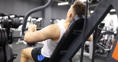 Sportif adam kol kaslarını şişirmek için egzersiz ekipmanı kullanır. Formda sporcu, ağır çekimden sonra modern spor salonunda yoğun egzersizden hoşlanır.