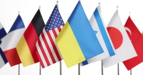 白い背景に世界の国のシンボルの前にウクライナの国旗 国際関係 平和のための支援と協力 — ストック動画