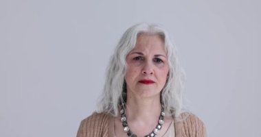 Donmuş vaziyette duran yaşlı kadın çok korkmuştu. Yaşlı kadın korkuyor ve kameraya bakıyor.