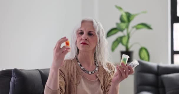 Skupiona Starsza Kobieta Trzymająca Rękach Butelkę Tabletek Dojrzała Pani Studiuje — Wideo stockowe