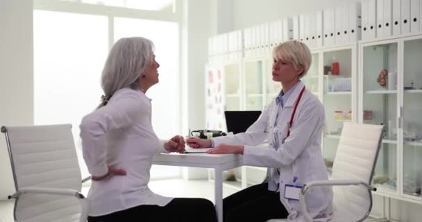 在医生预约时 忧心忡忡的成熟女人感到背痛 老年人背痛 — 图库视频影像