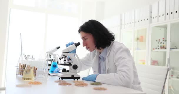 营养学专家在实验室里检测食品 科学家化学家在实验室用带有颗粒的试管对显微镜进行观察 — 图库视频影像