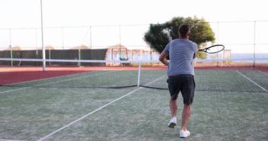 Profesyonel genç tenisçi sert korta vuruyor. Tenis oyunu