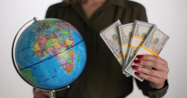 銀行券と女性の手の中に地球とアメリカの通貨ビジネスの概念 世界経済への強いドルの影響 — ストック動画