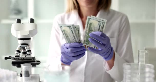 Naukowiec Rozważa Banknoty Dolarowe Pod Mikroskopem Laboratorium Badanie Lekarskie — Wideo stockowe