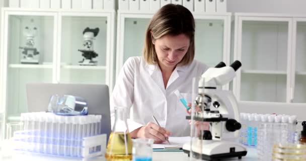 Laborassistentin Führt Klinische Laboruntersuchungen Durch Hält Reagenzglas Mit Blauer Flüssigkeit — Stockvideo