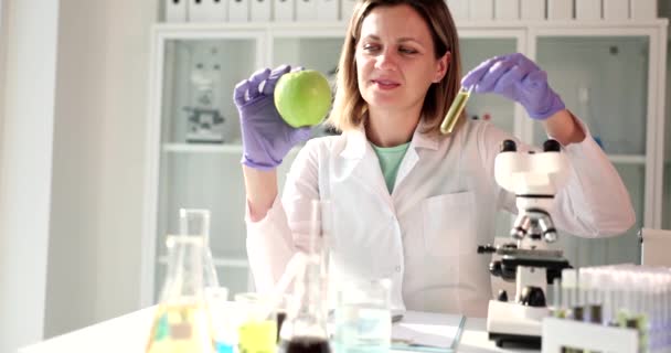Γυναίκα Επιστήμονας Κατέχει Φρέσκο Μήλο Και Δοκιμαστικό Σωλήνα Υγρό Στα — Αρχείο Βίντεο