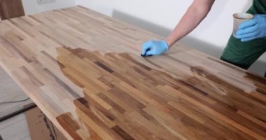 Marangoz, ahşap masayı koruyucu keten tohumu yağıyla kaplıyor. Ahşap masa yapma süreci