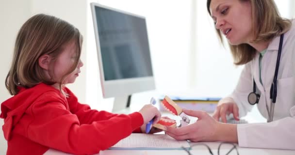 Γυναίκα Ορθοδοντικός Διδάσκει Παιδί Ασθενή Οδοντόβουρτσα Βουρτσίζουν Δόντια Στο Σαγόνι — Αρχείο Βίντεο