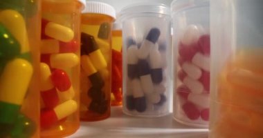 Renkli haplarla dolu plastik şişeler. Hem vücudu hem de cildi iyileştirmek için bol miktarda ilaç ve besin takviyesi