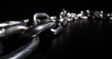 Siyah arkaplanda krom metalden yapılmış zincir halkalar. Güvenlik koruması