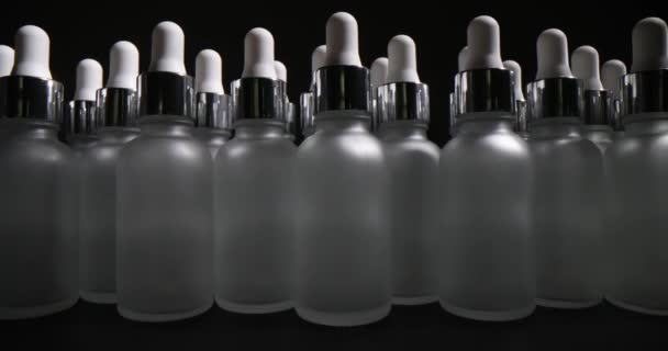 灰色の背景にドロッパー付きのフロストガラスボトル 化粧品包装の製造 — ストック動画