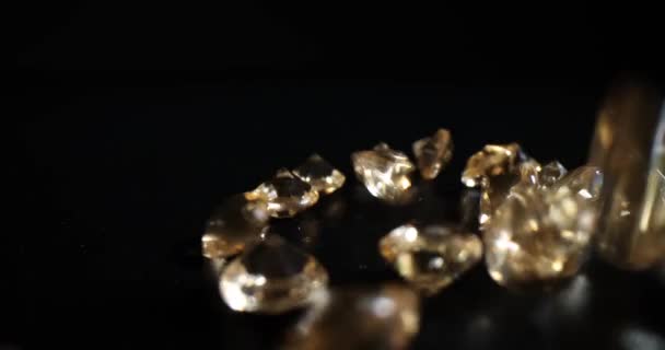 明るいダイヤモンドは暗いテーブルの上に投げられます ブラックを背景に高価なジュエリーを作るための豪華な宝石 — ストック動画