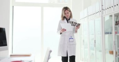 Hasta tıbbi belgelerine ve bilgisayar 4K filminde test sonuçlarına bakan kadın doktor. Doktor terapisti konsepti.