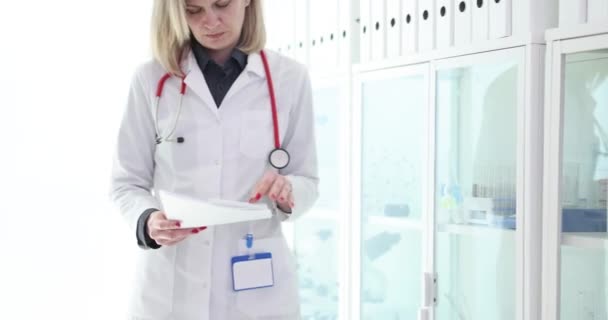 Kadın Doktor Ofiste Yürüyor Klinik Filminde Hasta Muayenesi Sonuçlarıyla Belgeleri — Stok video