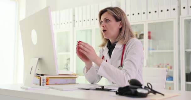 コンピュータ画面を見て クリニック4K映画スローモーションの患者の悪い結果を見て悲しい女性医師 遠隔医療の概念の問題 — ストック動画
