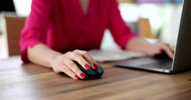 Bilgisayarda çalışan iş kadınının eli fareyi yakın çekimde 4K yavaş çekimde kullanıyor. Çevrimiçi çalışma kavramı