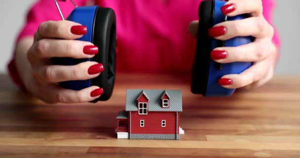 将建筑用耳机放在玩具屋4K电影慢动作上的女手 房屋和公寓隔音概念 — 图库视频影像